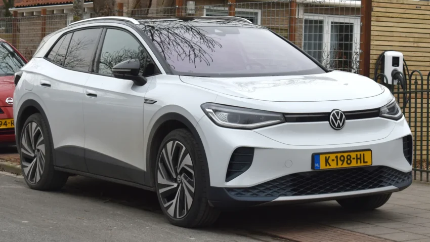 Volkswagen ID.4 Pro beyaz renk ön üç çeyrek görünüm, ev şarj istasyonunda şarj olurken