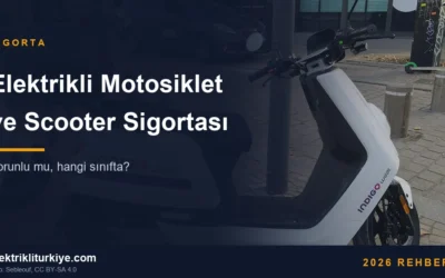 Beyaz elektrikli moped, şehir içinde park hâlinde, yandan görünüm. Fotoğraf: Sebleouf, CC BY-SA 4.0.